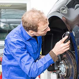 Image of mechanic inspecting brakes