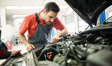 Image of mechanic working under hood of vehicle