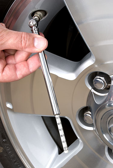 image of technician checking tire pressure on Toyota vehicle