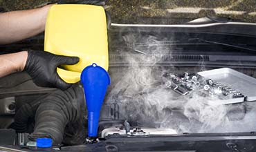 Cooling system/radiators image of technician adding coolant