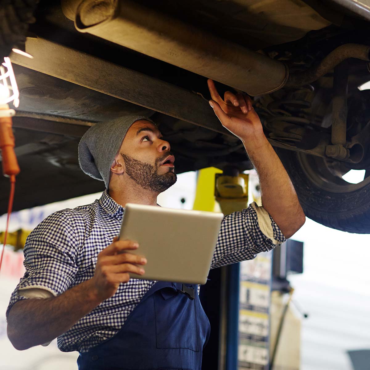 image of mechanic performing under car inspection